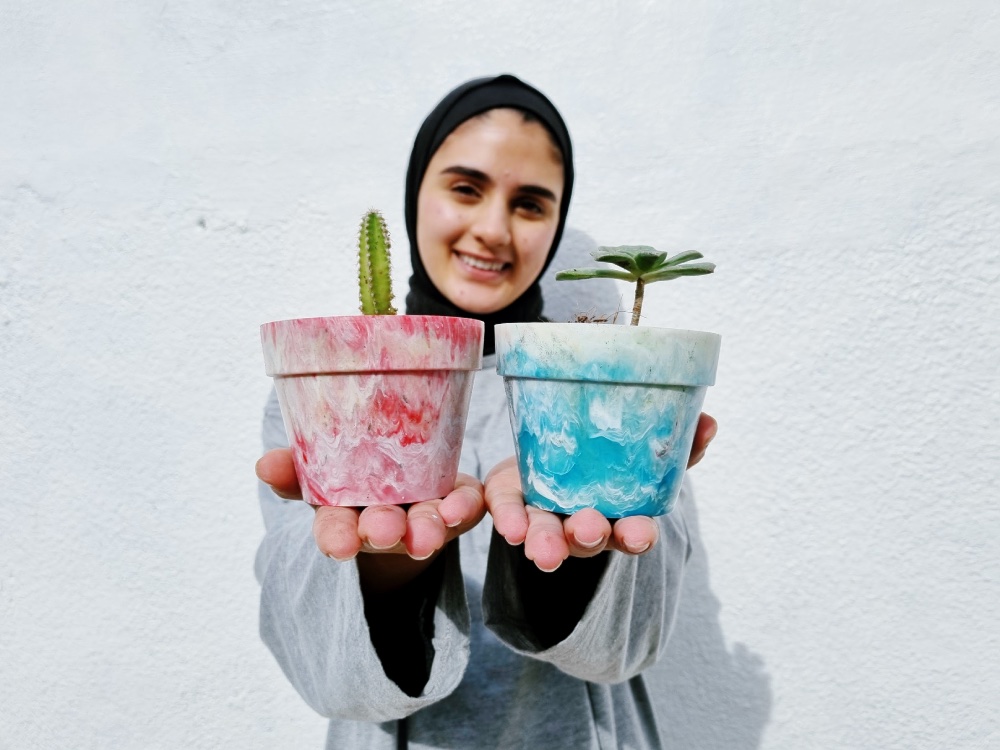 Veiled woman holding recycled vases