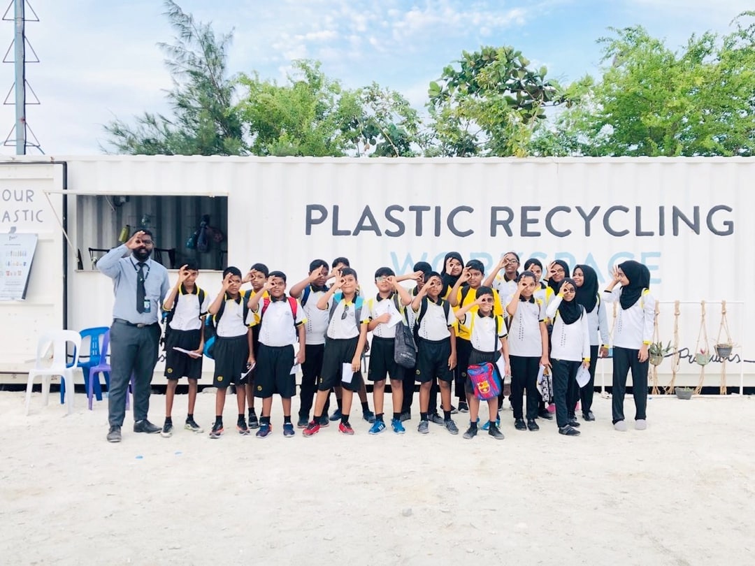 kids in front of recycling container
