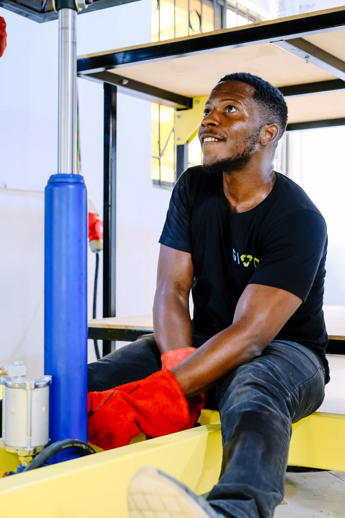 Nigerian man pumping a jack to recycle plastic